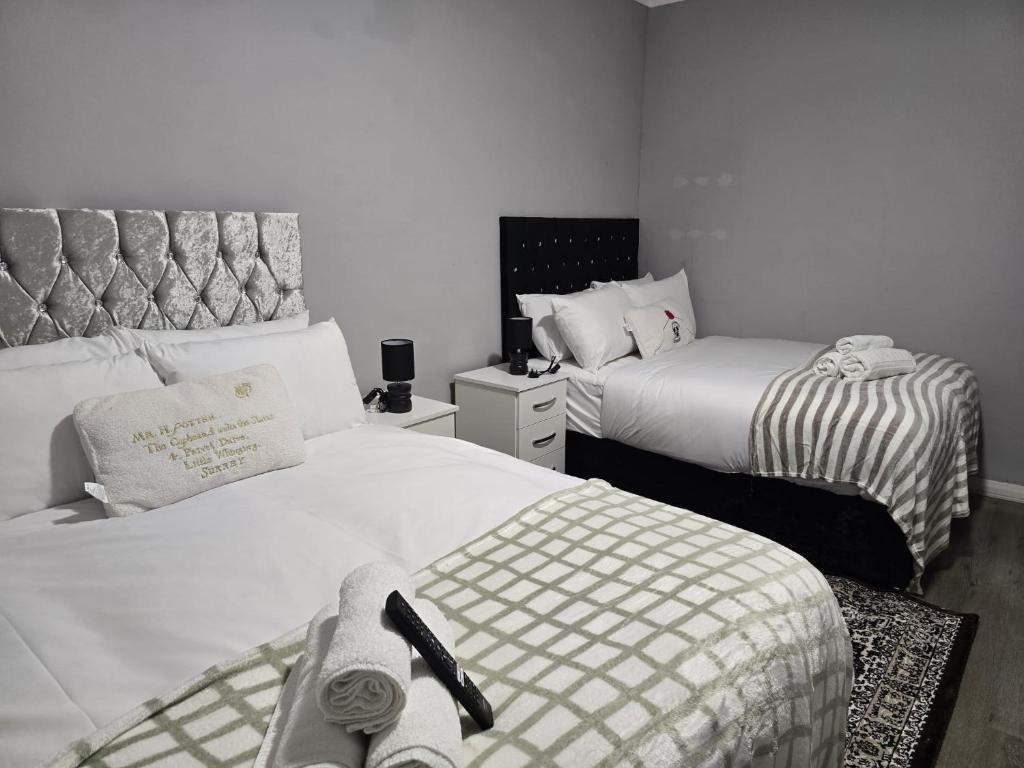 two beds in a small room with two beds sidx sidx sidx at Heathrow roomzzzz BnB in Hayes