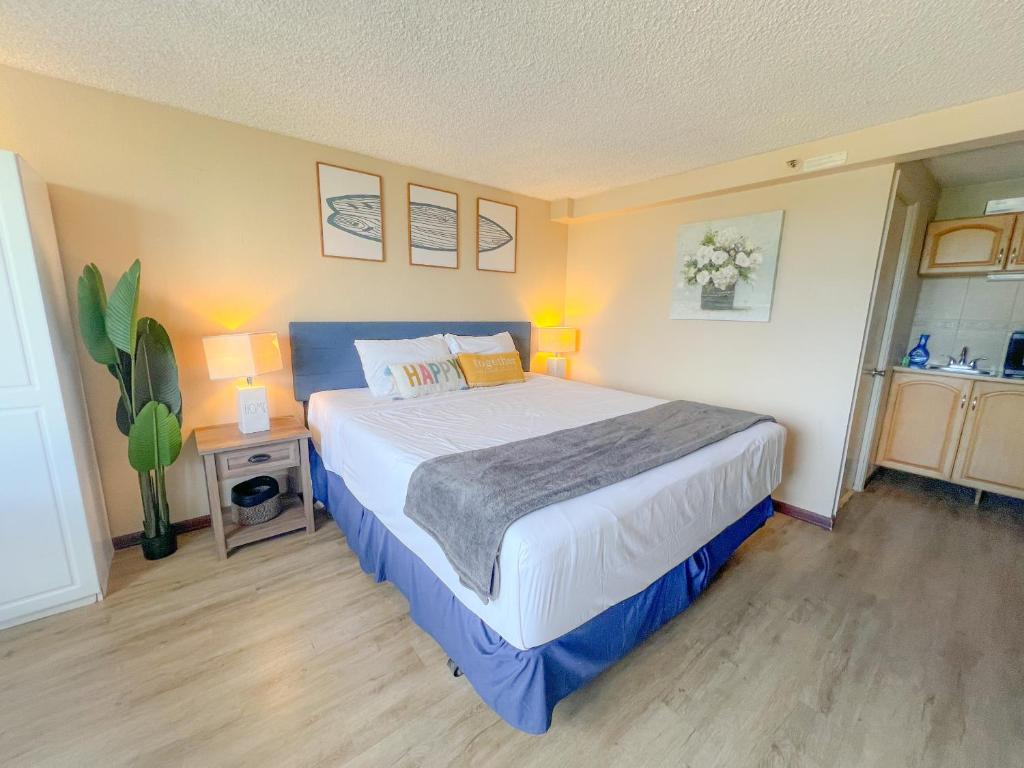 una camera da letto con un letto grande in una stanza di Happy Hawaiian Monarch Studio condo a Honolulu