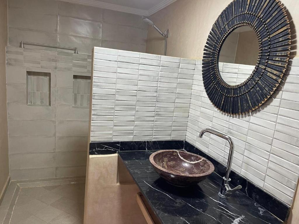 ein Badezimmer mit Waschbecken und Spiegel in der Unterkunft Riad Eglantine in Touggana