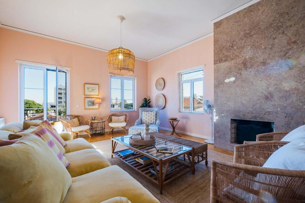 een woonkamer met een bank en een open haard bij Saboia -Spacious Gorgeous Apartment in Monte Estoril