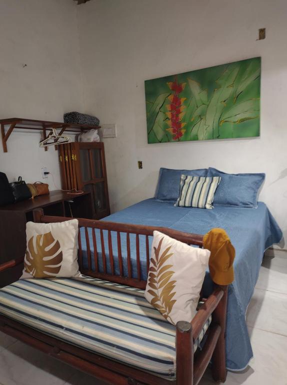 una camera con un letto con una panca e un quadro di Raízes kit net a Itacaré