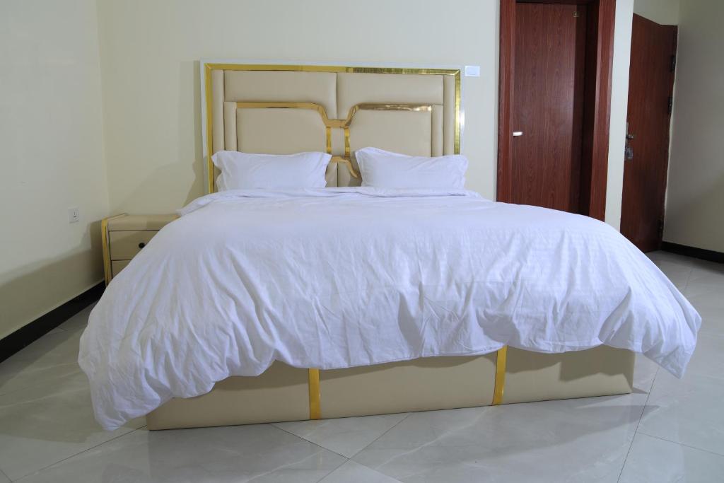 ein großes weißes Bett mit weißer Bettwäsche und Kissen in der Unterkunft My Dream Apartments - 4 miles from Bole International Airport in Addis Abeba