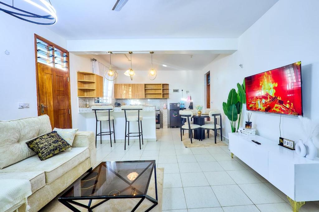 a living room and kitchen with a couch and a table at Diani beachview escape in Ukunda