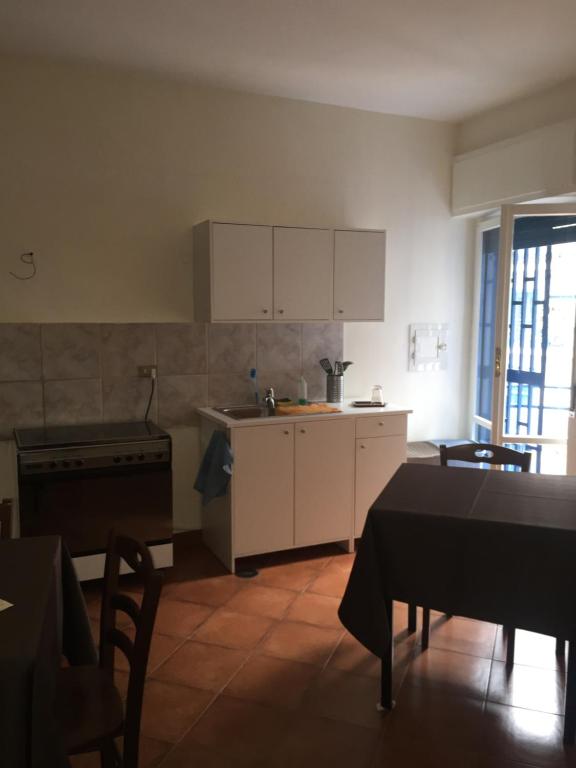 eine Küche mit weißen Schränken und einem Tisch darin in der Unterkunft B&B Napoli Napoli in Neapel
