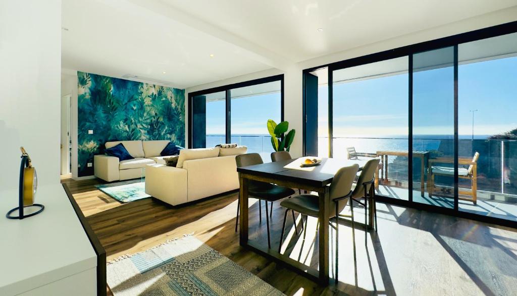 un soggiorno con un tavolo e un divano di Sea Front a Câmara de Lobos