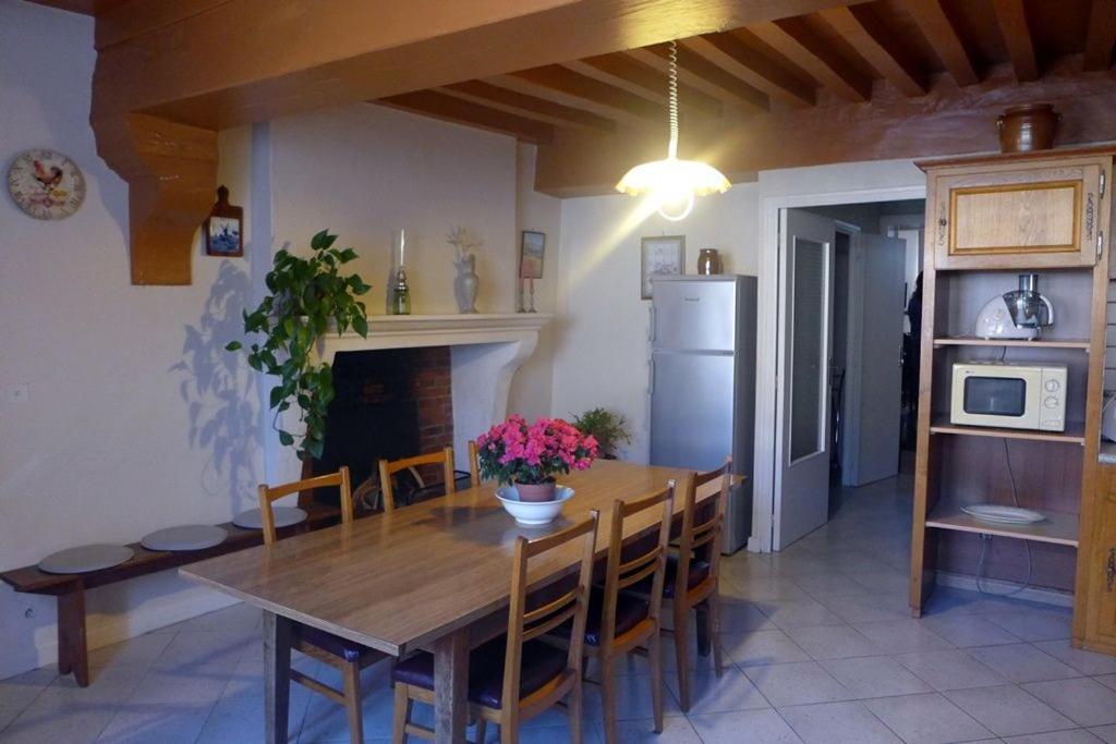 eine Küche und ein Esszimmer mit einem Holztisch und Stühlen in der Unterkunft Les pierres blanches in Aubepierre-sur-Aube