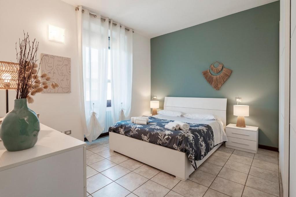 a bedroom with a bed and a vase on the floor at I Lavatoi Iseo - apartment in Iseo