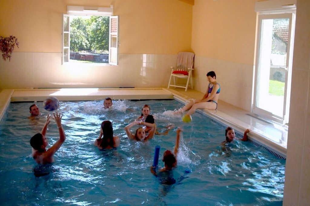 eine Gruppe von Kindern, die im Pool spielen in der Unterkunft Le paradis des goncourt in Goncourt