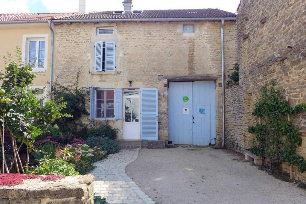 une maison en briques avec une porte bleue et une allée. dans l'établissement Eco gite de la rainette, à Chantraines