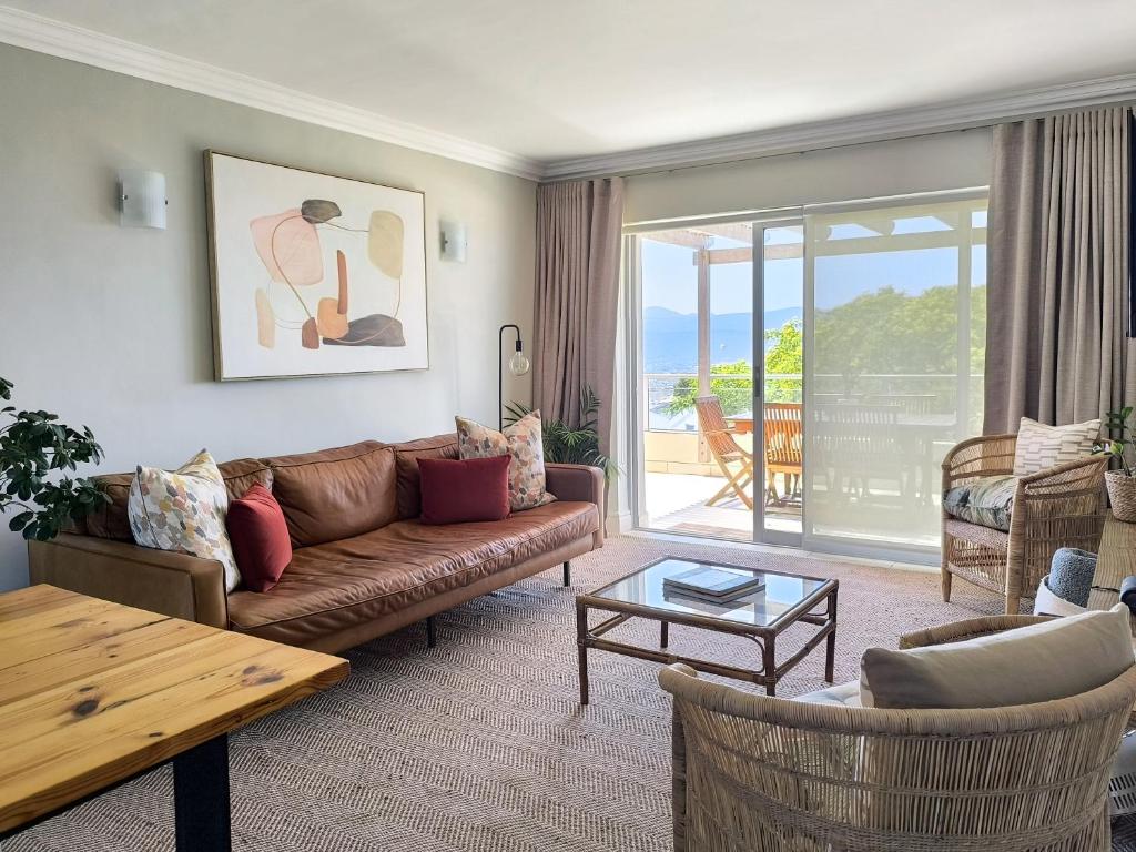 un soggiorno con un divano e un tavolo di Aquarella 15 a Plettenberg Bay