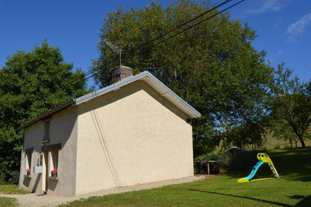 een klein huisje met een glijbaan op het gras bij La verte vallee in Orbigny-au-Val