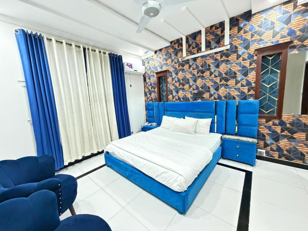 a bedroom with a blue bed and blue chairs at Sky Lodge Guest House in Islamabad