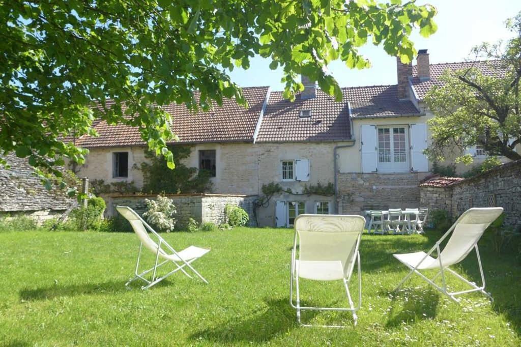 zwei Stühle im Gras vor einem Haus in der Unterkunft La maison de gabrielle in Giey-sur-Aujon