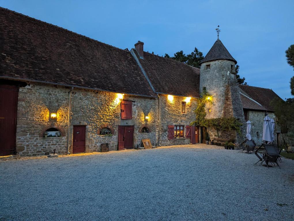 an old stone building with lights on it at Chateau De Montmagner in Arnac-la-Poste