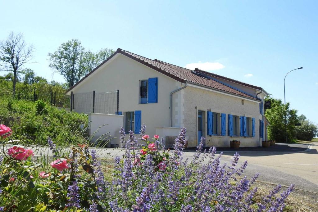 una casa con persiane blu e fiori davanti di L'etape du general a Colombey-les-deux-Églises