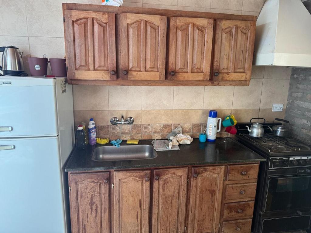 a kitchen with a sink and a white refrigerator at Osvaldo Day Cabin with Pool in Albardón