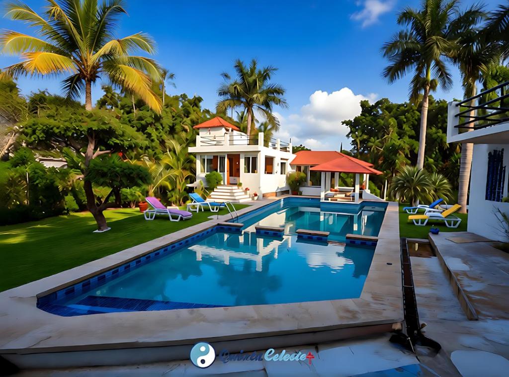 ein Swimmingpool vor einem Haus mit Palmen in der Unterkunft Quinta Celeste in Temixco