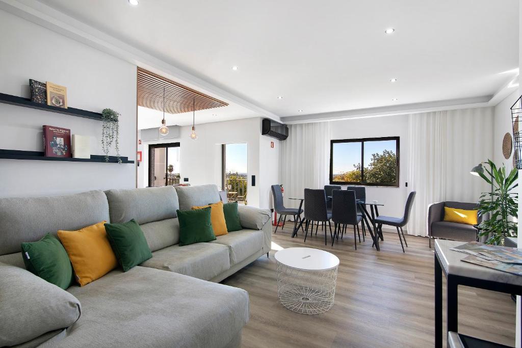 ein Wohnzimmer mit Couch und ein Esszimmer in der Unterkunft Casa das Amendoeiras in Pechão