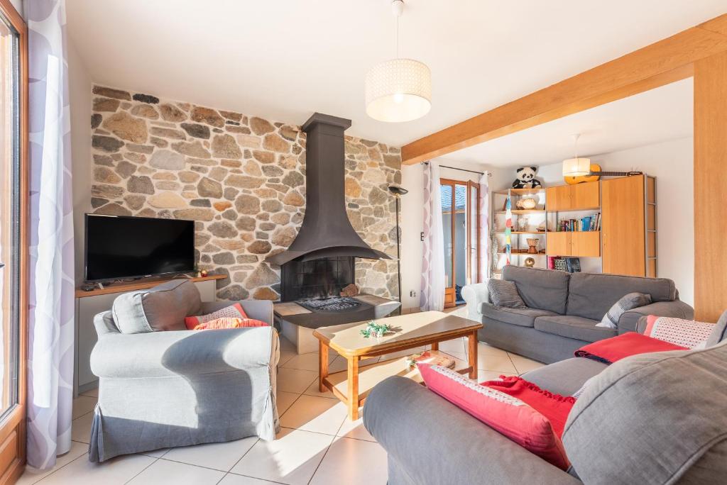 ein Wohnzimmer mit zwei Sofas und einem Kamin in der Unterkunft Maison Vacances Vue Montagnes in Arras-en-Lavedan