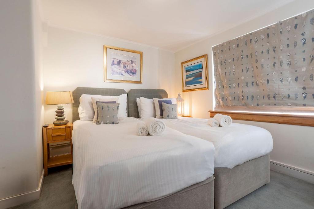 two white beds in a room with a window at Rockhopper Cottage Lower Largo in Lower Largo