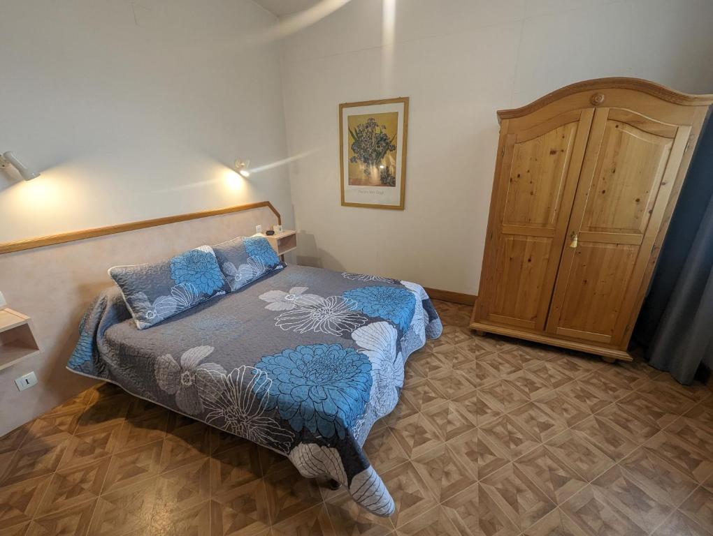 ein Schlafzimmer mit einem Bett und einem Holzschrank in der Unterkunft Lys in Bourbonne-les-Bains