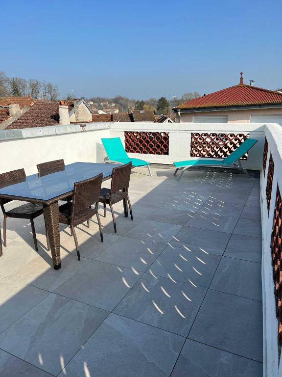 a patio with a table and chairs on a roof at Largo in Bourbonne-les-Bains