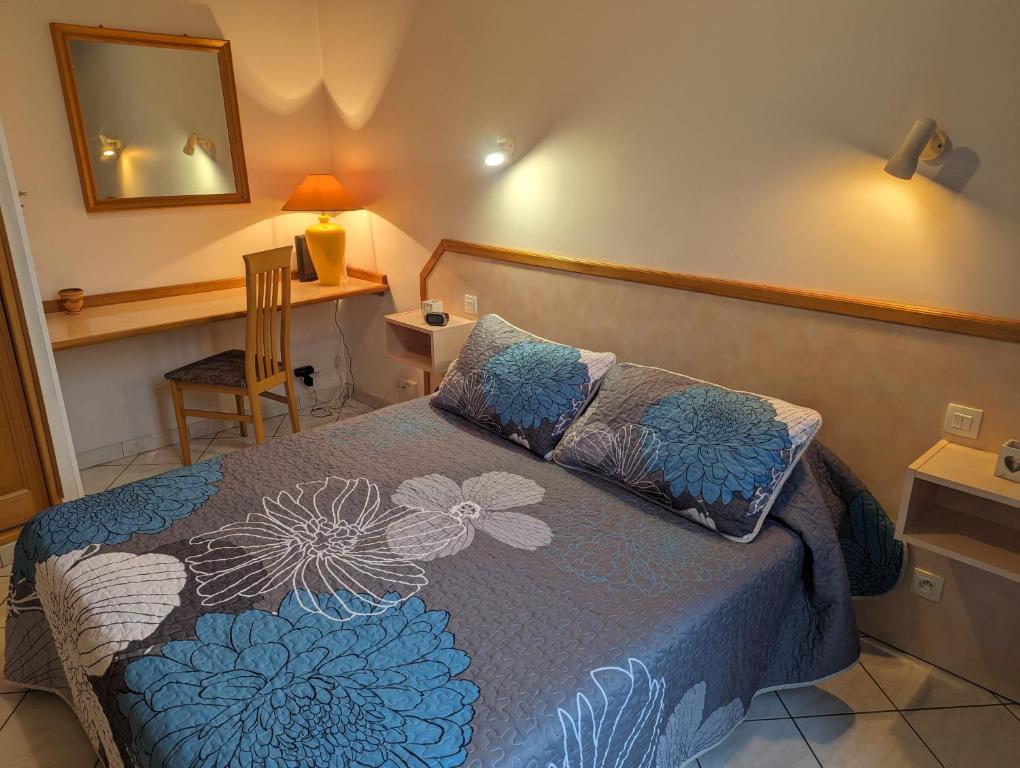 ein Schlafzimmer mit einem Bett, einem Spiegel und einem Stuhl in der Unterkunft Largo in Bourbonne-les-Bains