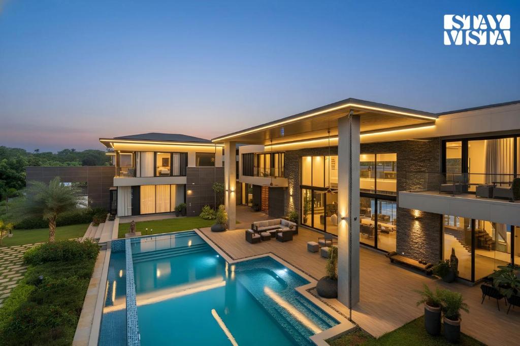 an image of a house with a swimming pool at StayVista at Acasa with Lawn in Alibaug