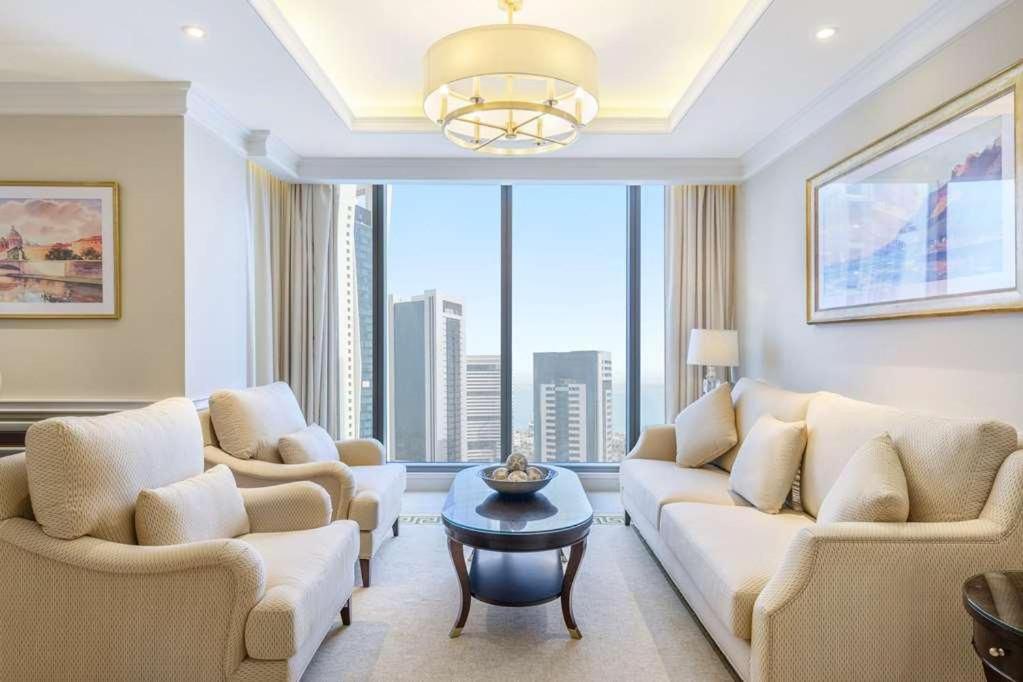 Westpac Hotel & Suites - Westbay Doha في الدوحة: غرفة معيشة مع أثاث أبيض ونافذة كبيرة