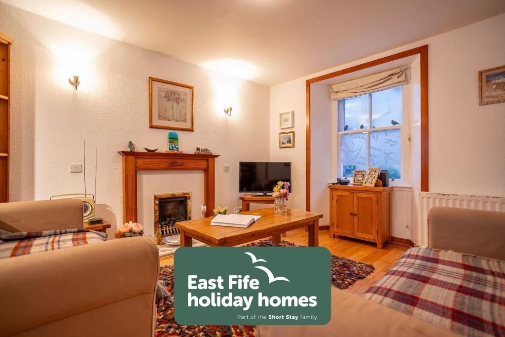 een woonkamer met een bank en een tafel bij West End No 18 - St Monans in Saint Monance