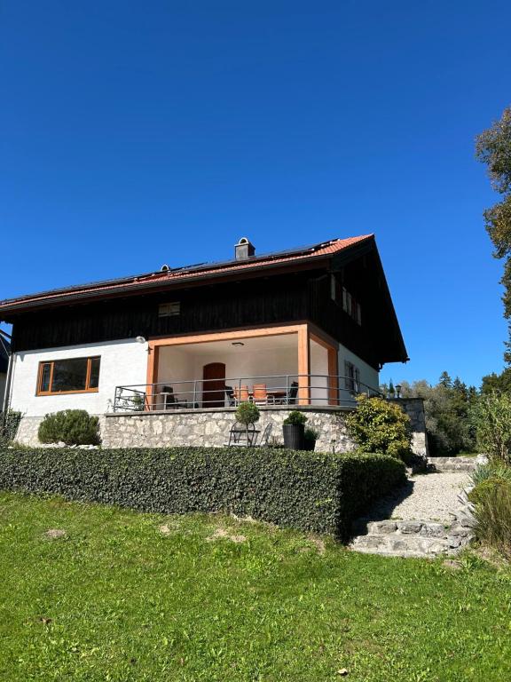 una casa con un tetto nero in cima a un cortile di Ferienhaus Westerbuchberg a Übersee