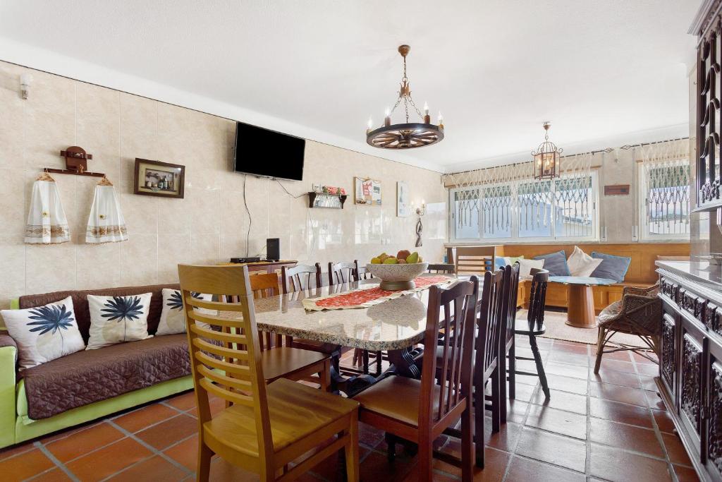 een eetkamer en woonkamer met een tafel en stoelen bij Casa Campo e Mar in Azenhas