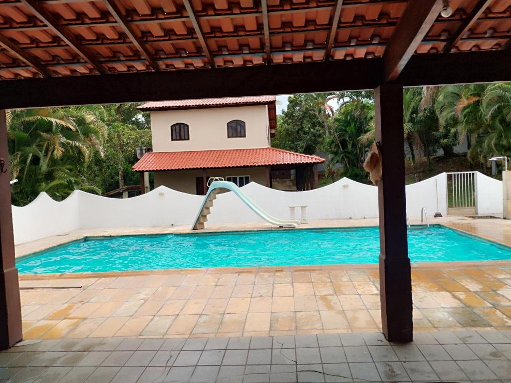una piscina con uno scivolo davanti a una casa di Paradise a Saquarema