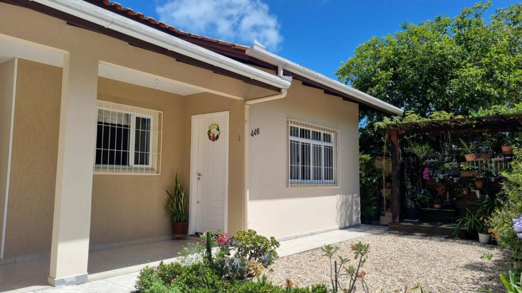 a house with a white door in a yard at Casa para 7 Pessoas em Bombas 600 m da Praia in Bombinhas