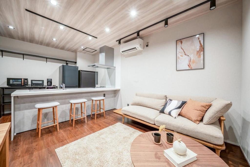 a living room with a couch and a kitchen at Restia Solace in Sapporo