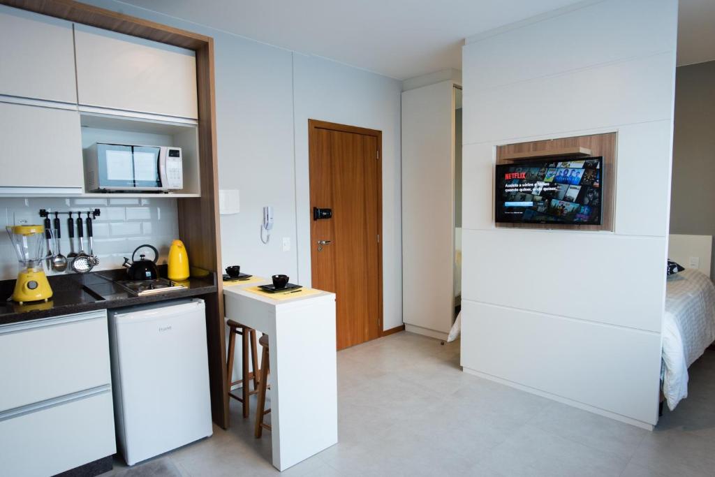 a kitchen with white cabinets and a counter top at Studio Prático Próximo ao Aeroporto in Florianópolis