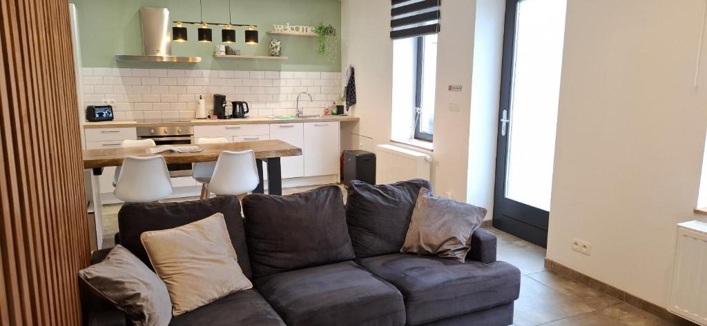 a living room with a couch and a kitchen at Gîte Chez Nénene La Roche en Ardenne in La Roche-en-Ardenne