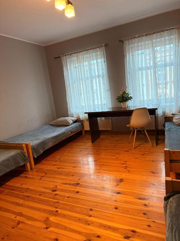 ein Zimmer mit einem Schreibtisch, einem Bett und einem Tisch in der Unterkunft Hostel Grudziadz in Graudenz