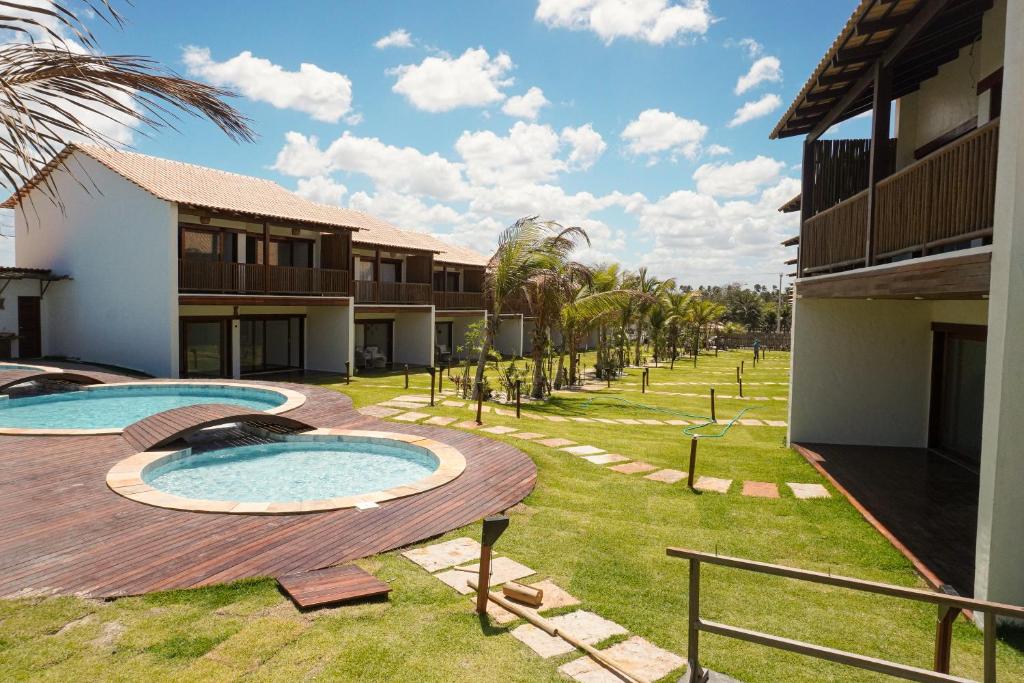 a resort yard with two pools and palm trees at Villa Conduru III Kite House Preá 100m from Beach in Cruz