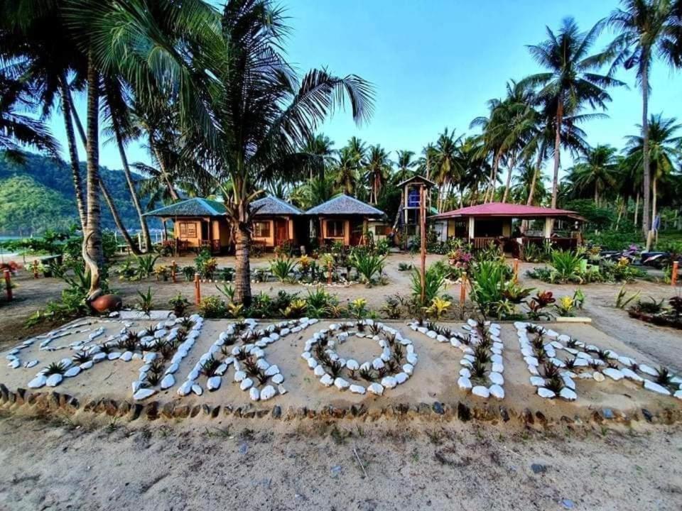 a peace sign in the sand in front of a resort at Akoya Beachpark and Cottages in El Nido