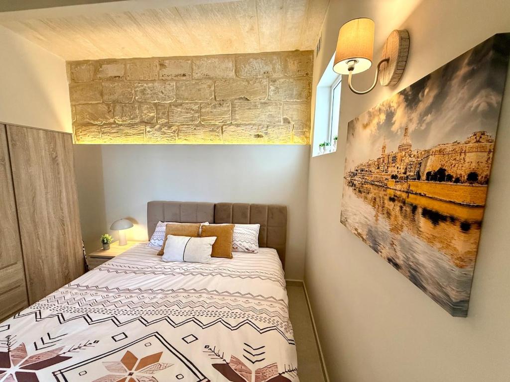 GudjaAS2 - The Alley Suites Apartment in Gudja的卧室里有一张床，墙上挂着一幅画
