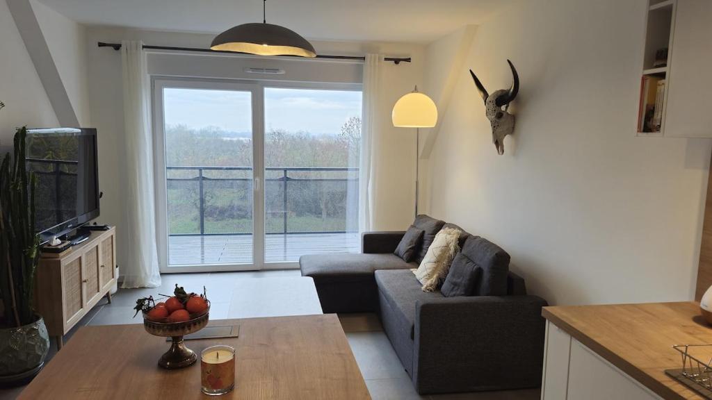 a living room with a couch and a television at Logement entier appartement Bischoffsheim in Bischoffsheim