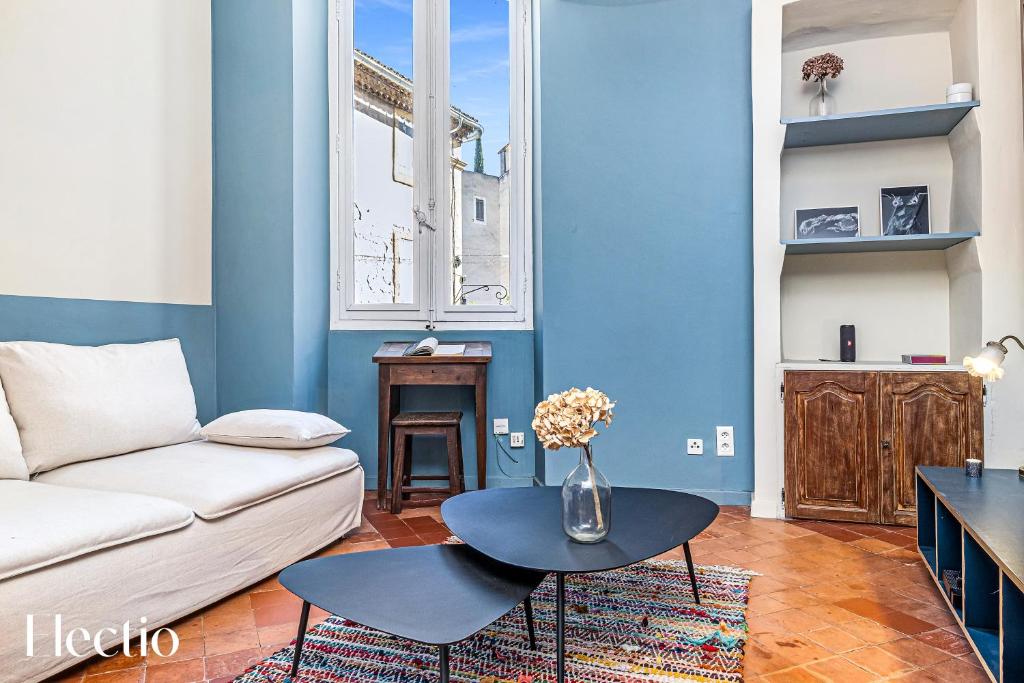 Maison de Caractère - Au cœur de Lourmarin في لورمارين: غرفة معيشة بها أريكة وطاولة