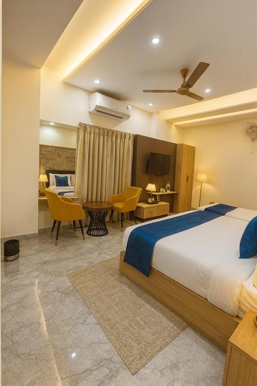 a bedroom with a bed and a table and chairs at Four Season Vrindavan # Near Prem Mandir # Luxury Rooms # Prime Location # Property Of The Year # By chandrodaya orchid # in Vrindāvan