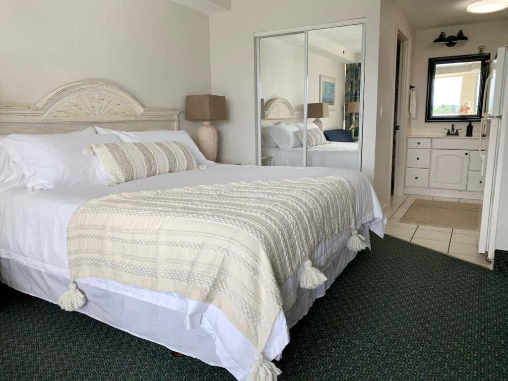 een slaapkamer met een groot wit bed en een spiegel bij Beach Access Elegant Studio near Top Attractions in Ortona