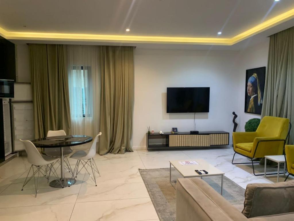 salon z kanapą i telewizorem w obiekcie The Pelican Lagos w mieście Badore