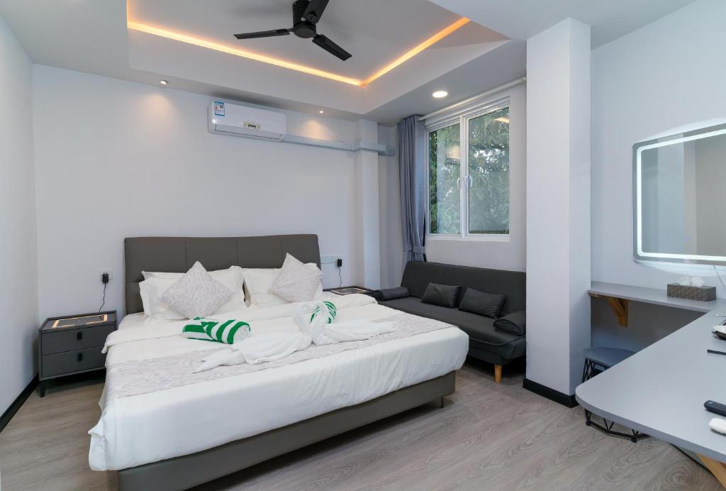 a bedroom with a large white bed and a couch at Sunway Ukulhas in Ukulhas