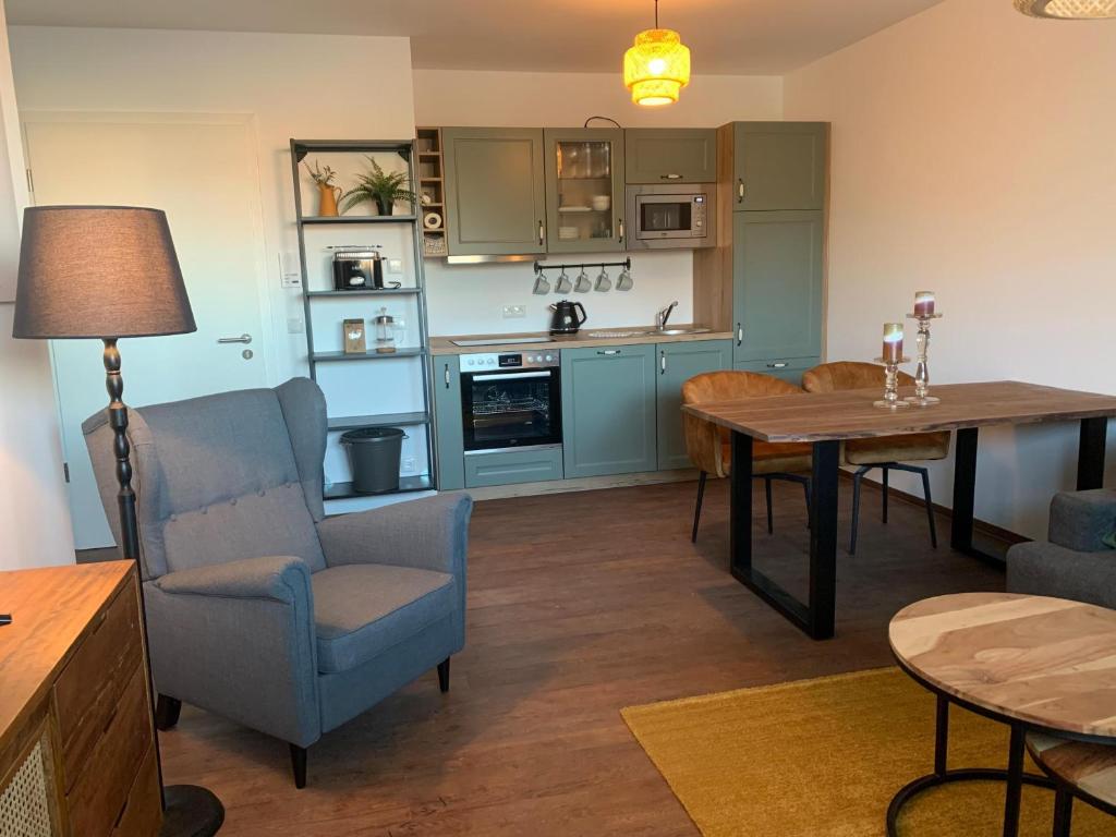 a living room with a table and a kitchen at Am Hafen 15 in Röbel