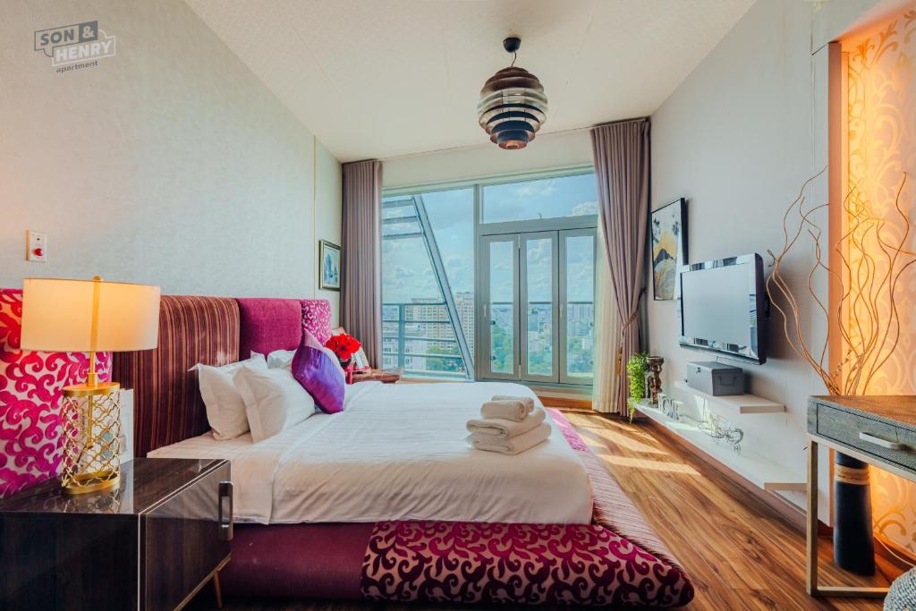 a bedroom with a large bed and a large window at Son&Henry Sailing Tower in Ho Chi Minh City