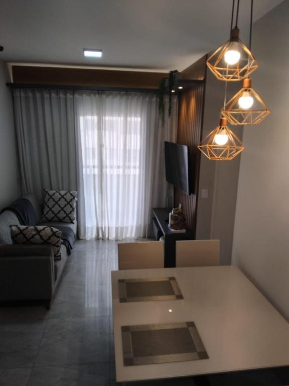 un soggiorno con un divano, un tavolo e delle luci di Amy House a Vila Velha